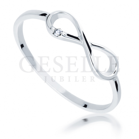 Delikatny pierścionek w kształcie symbolu nieskończoności z białego złota z lśniącym brylantem o masie 0.01 ct